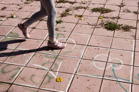 Girl playing hopscotch on the playgroundの写真素材