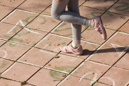Girl playing hopscotch on the playgroundの写真素材