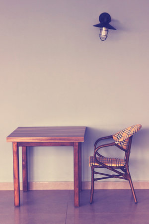 Chair and table.Empty chair and table against the wall
