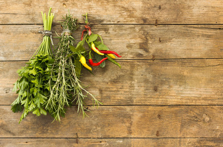 Bunches herbs hanging on a wooden boardの写真素材
