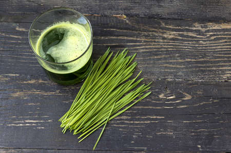 Wheat grass juice on dark wood backgroundの写真素材