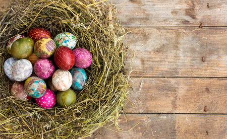 Colorful painted and decorated Easter eggs in a nest of hayの写真素材