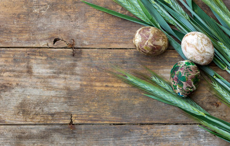 Easter eggs and young wheat on a rustic wooden background, top viewの写真素材
