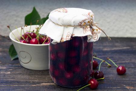 Jar with sour cherry compote on the wooden tableの写真素材