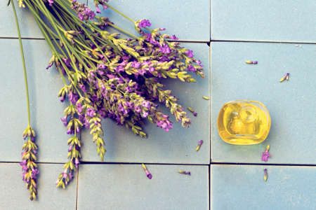 Lavender flowers  and a bottle of lavender oil on the ceramic background..Toning effectの写真素材