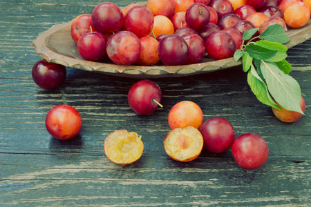 Ripe plums fruit with slices on wooden  background - vintage lookの写真素材