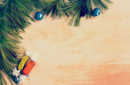 Christmas border with pine tree branches and  candy  on wooden boardsの写真素材