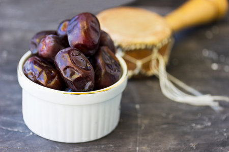 Dried dates fruit in a bowl on wooden background