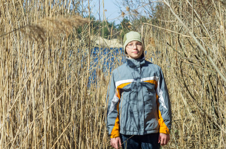Portrait of boy standing on the bank of the river Stugna in the reedsの写真素材