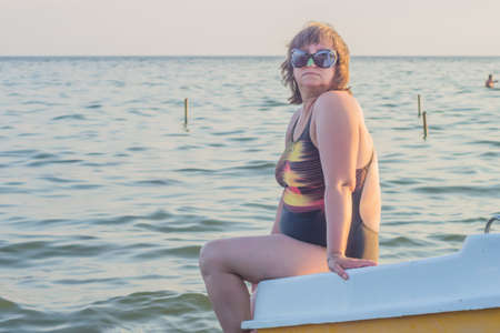 A woman wearing sunglasses against the seaの写真素材