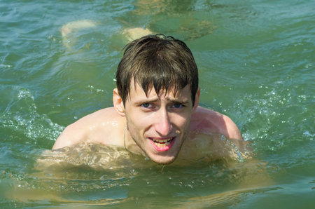 Portrait of a youngman in a sea laughingの写真素材