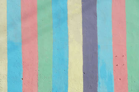 Fragment of bright painted concrete plastered wall. Striped rainbow background. Rough wall texture. Photoの写真素材