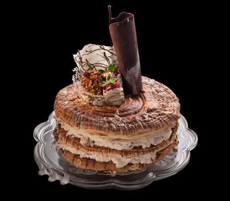 cake with cream and chocolate cream decoration on black background