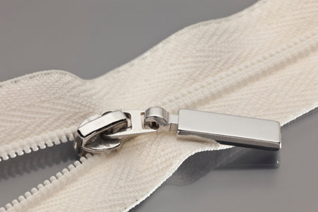 studio photography of beige zipper opened on a half to a gray surface