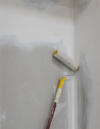 detail of unfinished  wall in apartment and paint rollerの写真素材