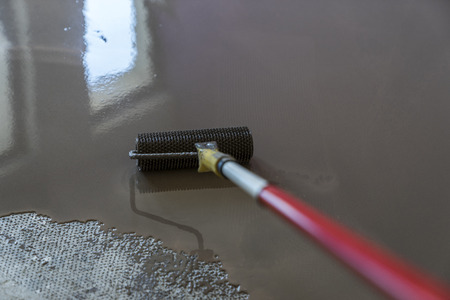 Floor covering with self leveling plaster. Roller application. Mirror smooth surface of the floorの写真素材