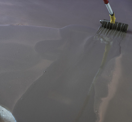 Interior of apartment under construction. Roller application. Floor covering with self leveling plaster. Mirror smooth surface of the floorの写真素材