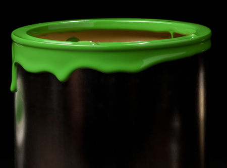 Colorful paint leaking down on wall of metal bucket. Isolated over black backgroundの写真素材