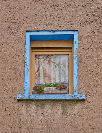 vintage window with blue frame and flowersの写真素材