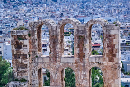 arches of Herodion theater on Athens cityscape backgroundの写真素材