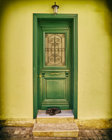 Greece, vintage green wooden door on yellow house door, filtered