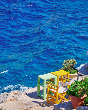 colorful tables and chairs by the seaの写真素材