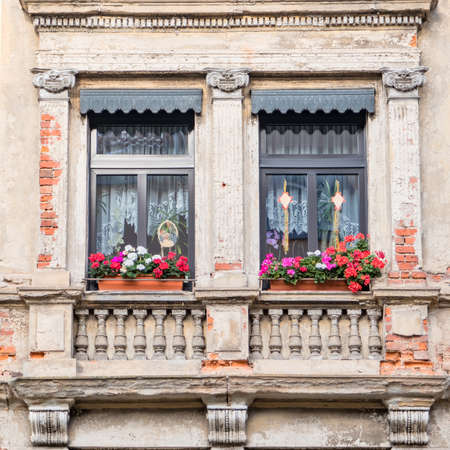 windows with geranium flower pots, old house facade detailの写真素材