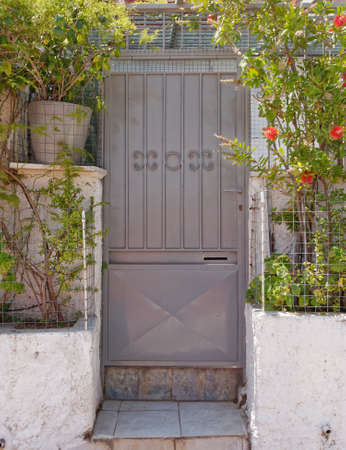 house entrance metallic gray door and flowers, Athens Greece, Anafiotika neighborhoodの写真素材