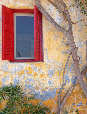 Athens Greece, red window of picturesque house exterior, Anafiotika district in Plaka old...