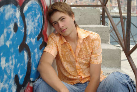 Young boy sitting against wallの写真素材