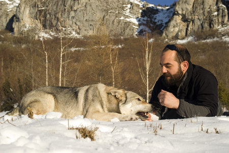 Man with dog in winter forest