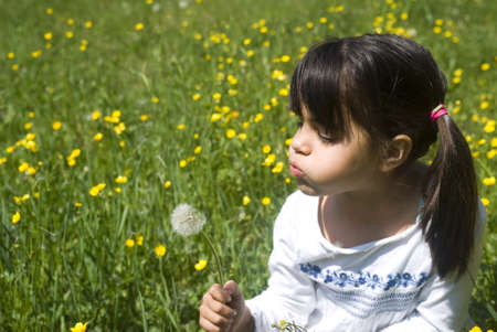 Girl blowing a dandelionの写真素材
