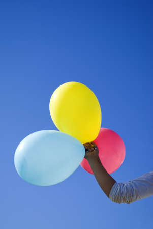 Hand holding coloured balloonsの写真素材