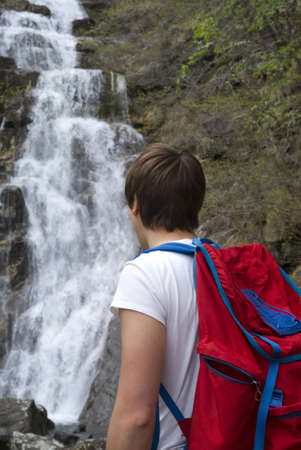 Hiker standing near waterfallの写真素材