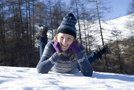 Smiling woman laying in snowの写真素材