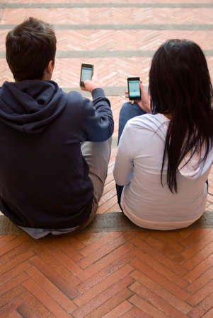 Teens with mobile phones outdoorの写真素材