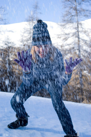 Playful woman throwing snow