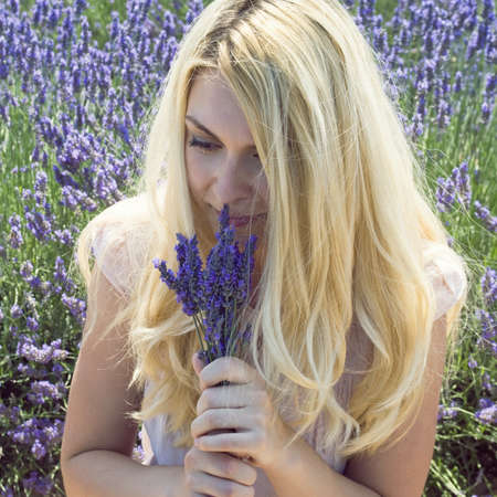 Woman on a meadow with lavender flowersの写真素材