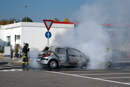 Firemen extinguishing a car fire