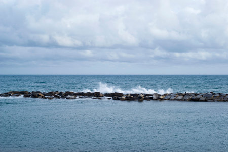 Stone breakwater with breaking wavesの写真素材
