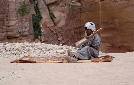 Petra, Jordan - October 26, 2016: Bedouin senior man playing stringed instrument at the ancient site of Petra in Jordanのeditorial素材