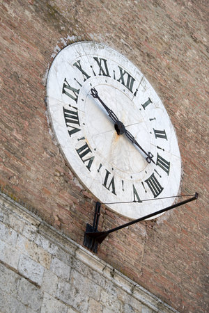 Clock on facade of the old hospital Santa Maria della Scala, Siena, Tuscany, Italy