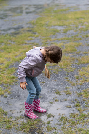Girl jumping in the puddle