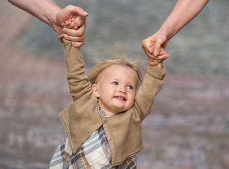 Parents holding daughter by the handsの写真素材