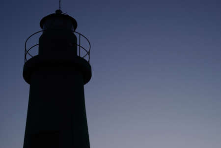 Silhouette of lighthouse at evening lightの写真素材