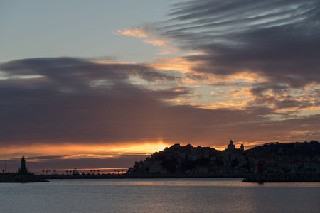 Dramatic colorful clouds at sunset with cityscape silhouette - Imperia, Liguria, Italyの写真素材