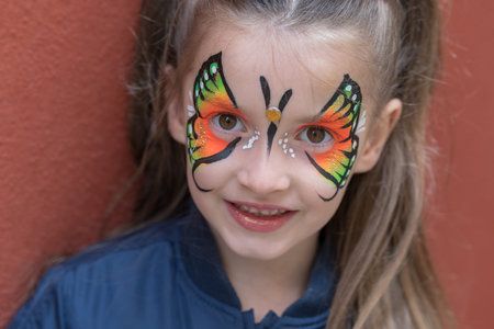 Close up of girl with butterfly painted on faceの写真素材
