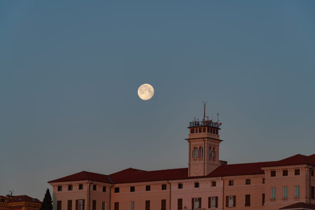 Sunrise full moon over city buildingの写真素材