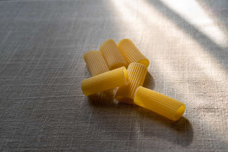 Uncooked rigatoni pasta on table の写真素材