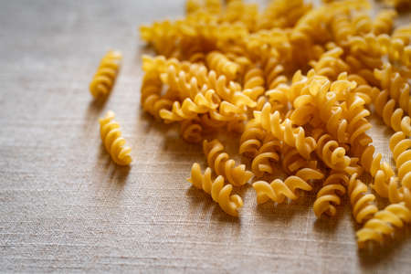 Uncooked fusilli pasta on tableの写真素材